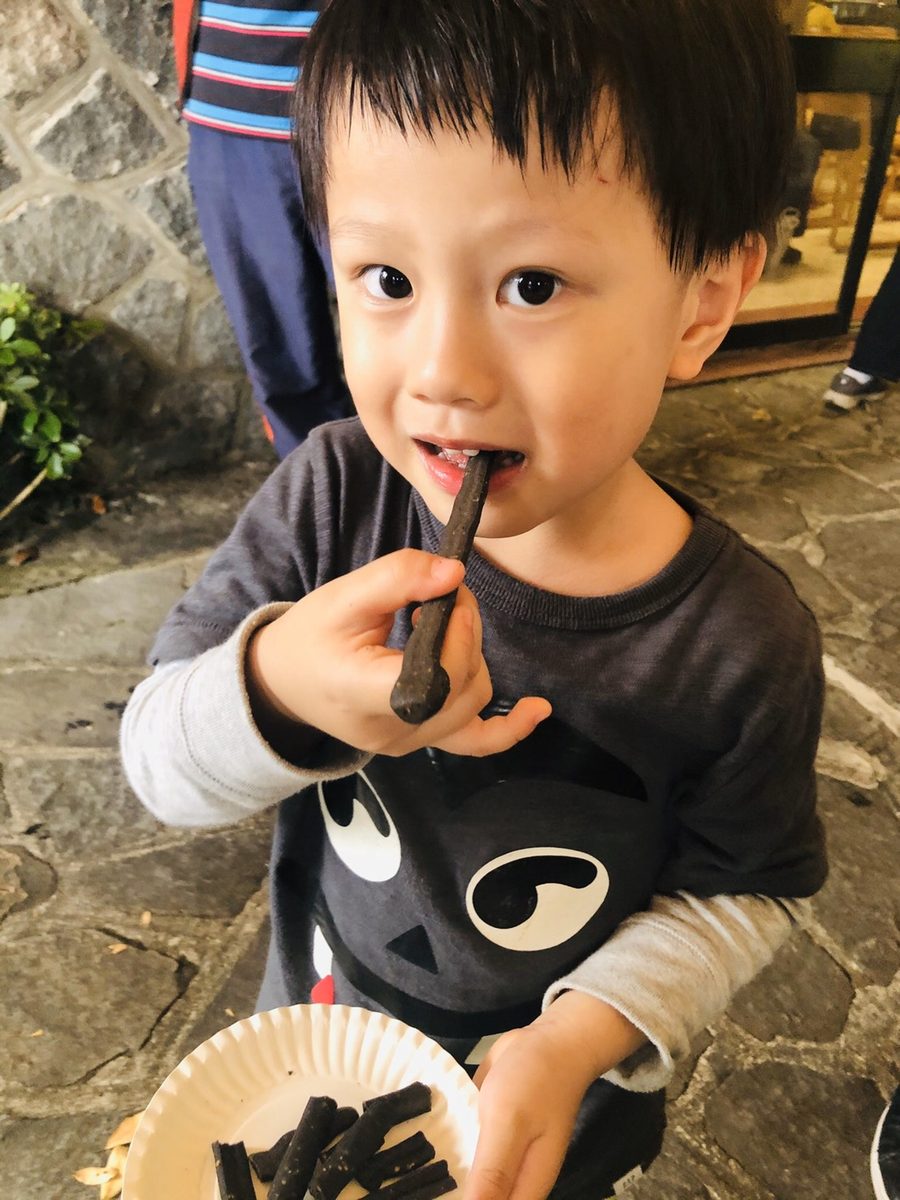 A child happily tasting a BlackHut squid ink breadstick